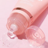 Medicube Collagen Night Wrapping Mask poured from tube with cap open on pink background.