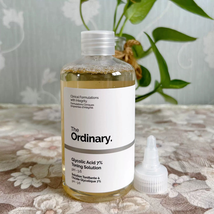 The Ordinary Glycolic Acid 7 Toner bottle with dropper on a floral tablecloth.